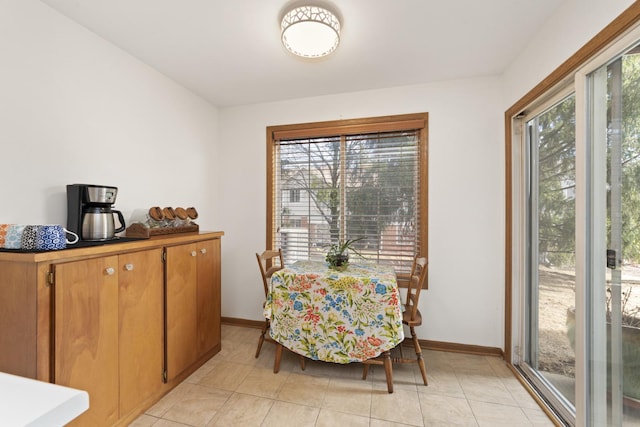 dining area featuring light tile patterned floors and baseboards