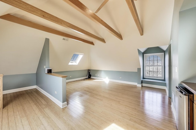 bonus room with light wood finished floors, visible vents, lofted ceiling with skylight, and baseboards