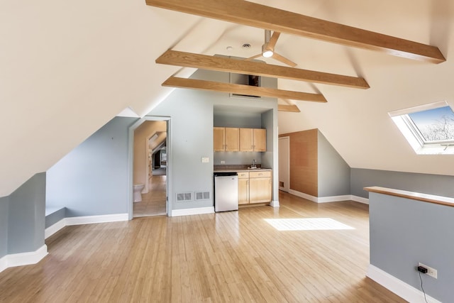 additional living space featuring a sink, baseboards, and light wood finished floors