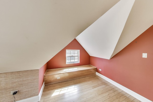 additional living space featuring lofted ceiling, baseboards, and wood-type flooring