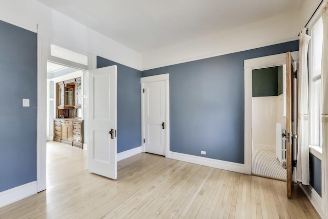 interior space featuring light wood finished floors and baseboards