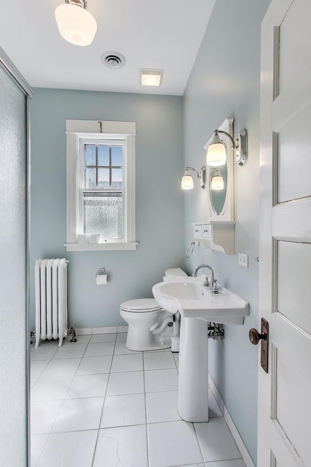 bathroom featuring tile patterned floors, visible vents, toilet, radiator heating unit, and baseboards