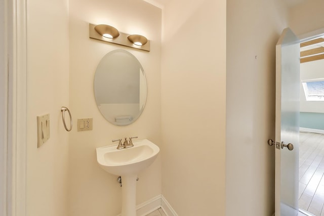 bathroom with a sink, baseboards, and wood finished floors