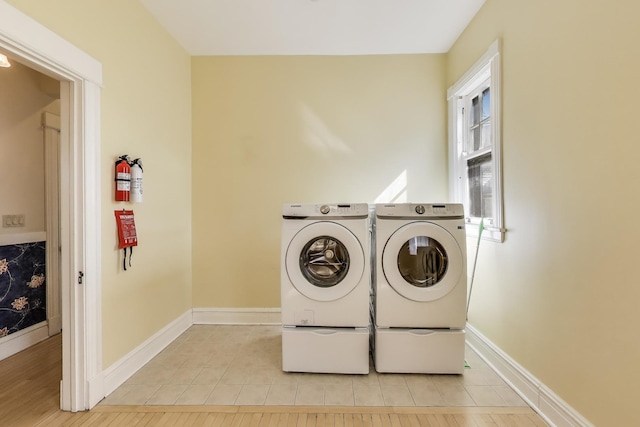 washroom featuring light tile patterned floors, baseboards, independent washer and dryer, and laundry area