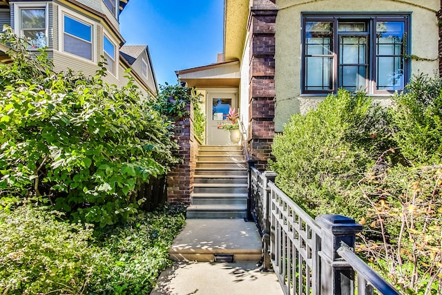 view of exterior entry with brick siding and stucco siding