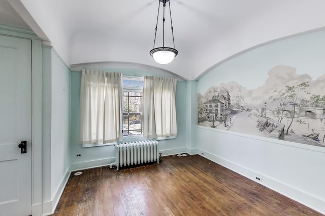 empty room with radiator, baseboards, and wood-type flooring