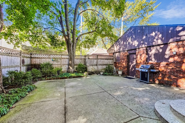 view of patio featuring a grill and fence