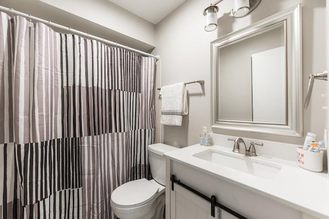 bathroom featuring curtained shower, toilet, and vanity