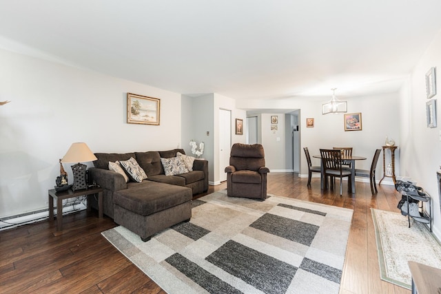 living area with an inviting chandelier, baseboards, and wood-type flooring