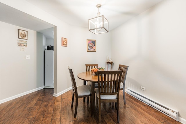 dining space featuring a baseboard heating unit, wood-type flooring, a notable chandelier, and baseboards