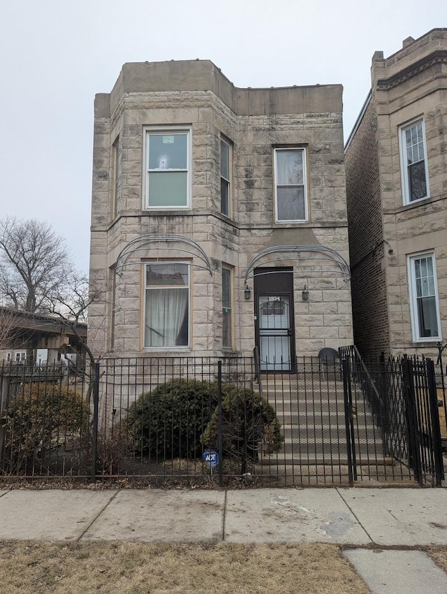 1934 S Saint Louis Ave, Chicago, IL 60623 - view of front facade featuring stone siding and a fenced front yard