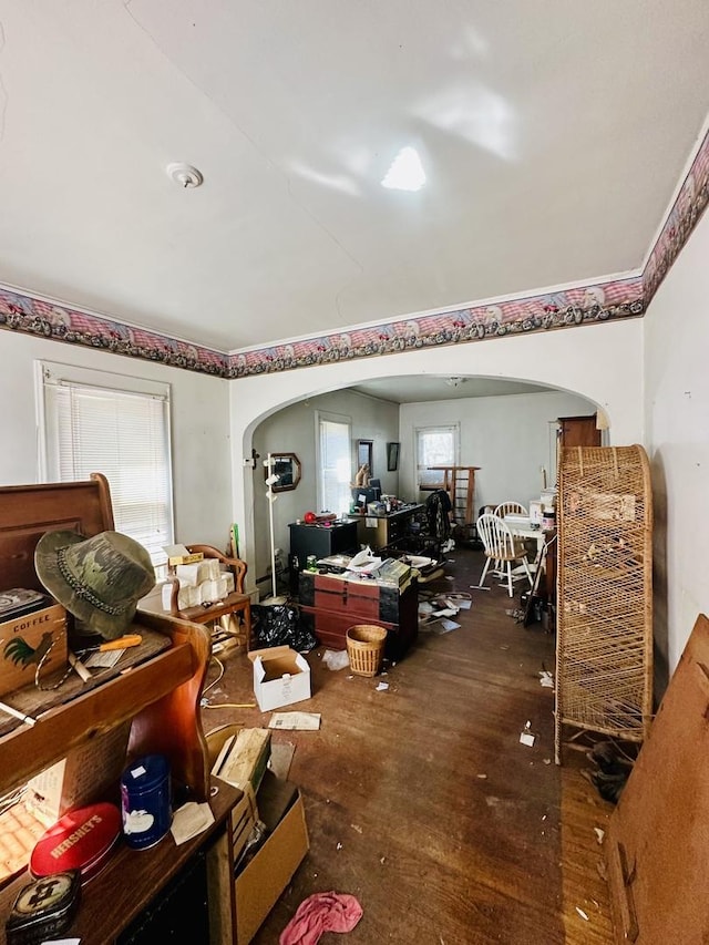 misc room featuring arched walkways and wood finished floors