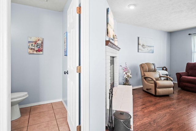 interior space with light tile patterned floors, baseboards, and a textured ceiling