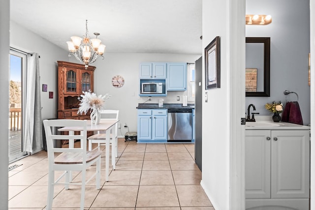 kitchen featuring light tile patterned flooring, blue cabinets, and stainless steel appliances