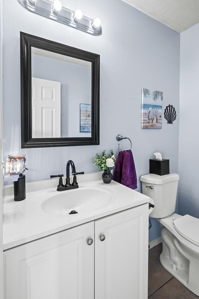 bathroom with tile patterned flooring, toilet, and vanity