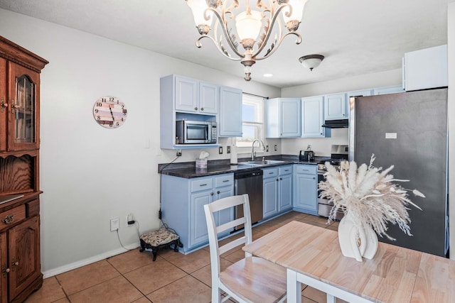 kitchen with a notable chandelier, blue cabinetry, dark countertops, stainless steel appliances, and light tile patterned flooring