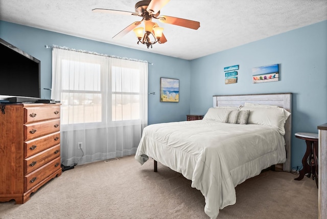 bedroom featuring light carpet, a textured ceiling, and ceiling fan