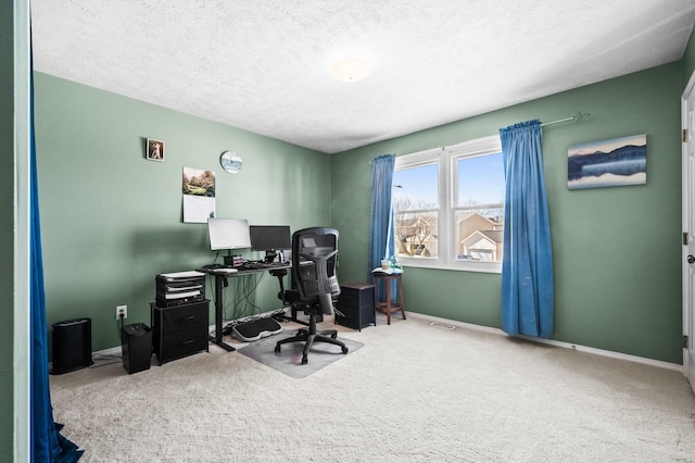 carpeted home office with visible vents, baseboards, and a textured ceiling