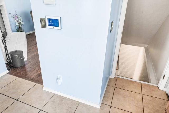 hallway featuring tile patterned flooring and baseboards