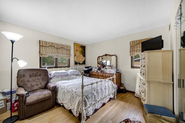 bedroom featuring baseboards and light wood finished floors