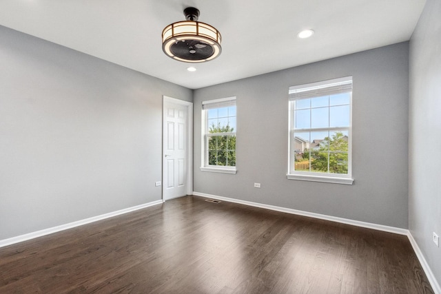 unfurnished room with plenty of natural light, recessed lighting, baseboards, and dark wood-style flooring