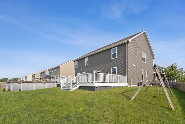 rear view of house featuring a yard, a deck, and fence