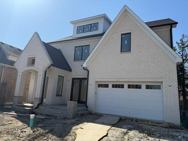 view of front of home with brick siding and an attached garage