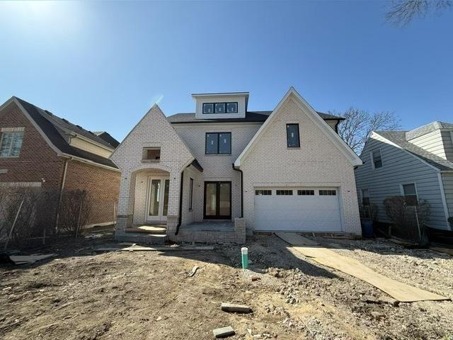 view of front of property featuring french doors, brick siding, and an attached garage