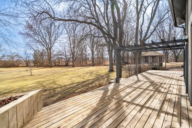 wooden deck featuring a lawn and a pergola