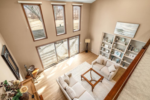 living area with a high ceiling and wood finished floors