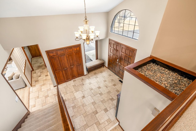 entrance foyer with a chandelier, stairway, and a towering ceiling