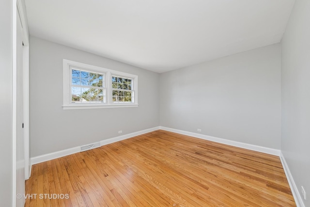 empty room featuring visible vents, light wood-style flooring, and baseboards