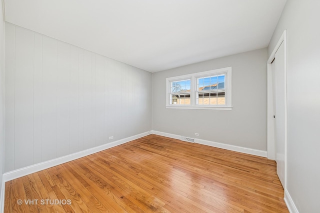 unfurnished bedroom featuring light wood-style floors, visible vents, a closet, and baseboards