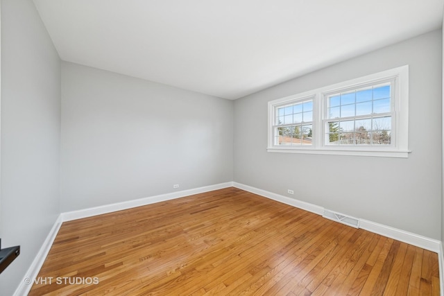 empty room featuring light wood-type flooring and baseboards