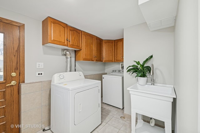 washroom featuring cabinet space, tile walls, washing machine and dryer, and light tile patterned flooring