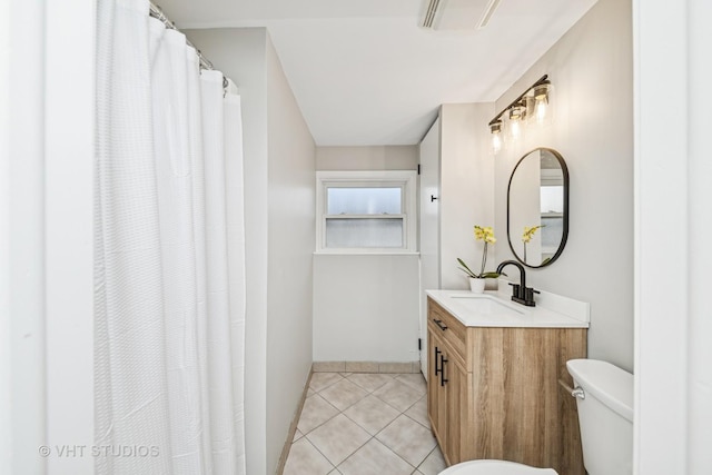 bathroom with vanity, visible vents, baseboards, tile patterned flooring, and toilet