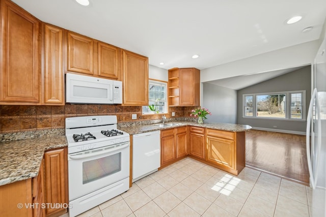 kitchen featuring a sink, open shelves, light stone counters, backsplash, and white appliances