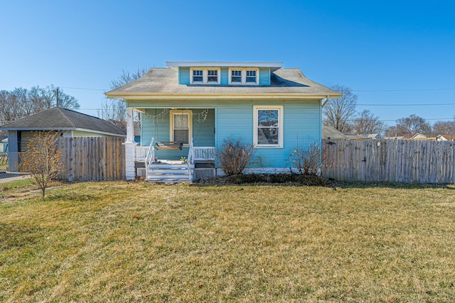 bungalow-style home featuring a porch, a front lawn, and fence