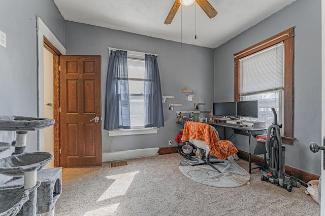carpeted home office featuring baseboards, visible vents, a wealth of natural light, and ceiling fan