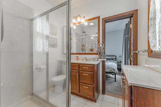 bathroom with tile patterned floors, toilet, a stall shower, and vanity