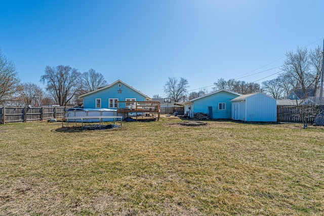 view of yard with an outbuilding, a fenced in pool, a wooden deck, and a fenced backyard