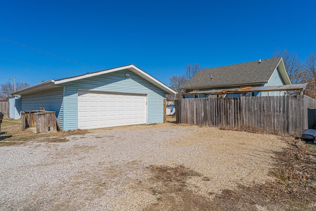 detached garage featuring fence