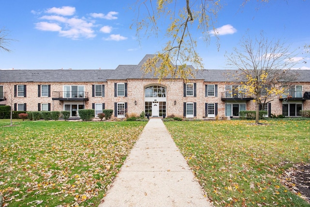 view of front of house featuring brick siding and a front yard