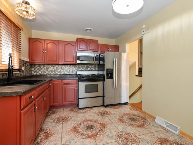 kitchen with a sink, tasteful backsplash, visible vents, and stainless steel appliances