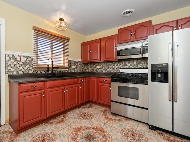 kitchen featuring decorative backsplash, visible vents, appliances with stainless steel finishes, and a sink