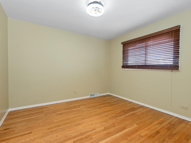 spare room with visible vents, baseboards, and light wood-style floors