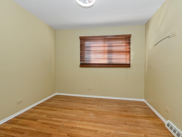 unfurnished room with light wood-type flooring, visible vents, and baseboards