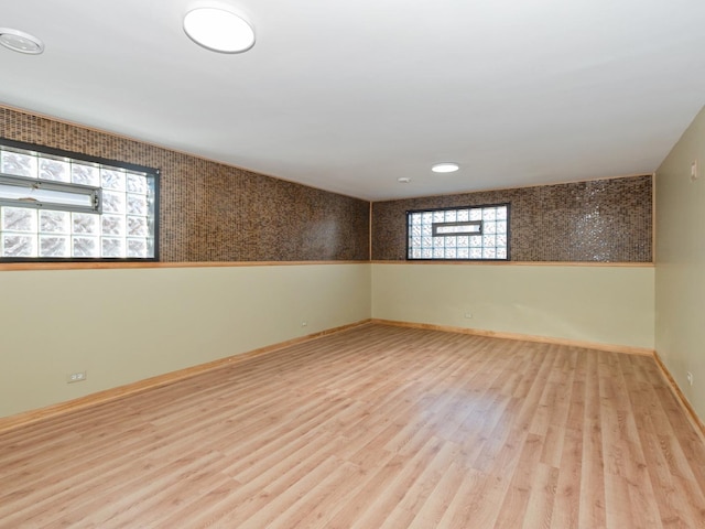 spare room featuring wainscoting, baseboards, and wood finished floors