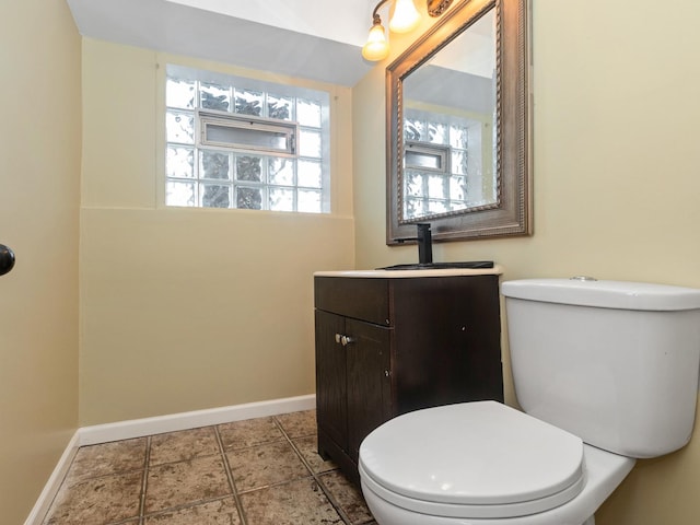 half bath with tile patterned floors, toilet, and baseboards