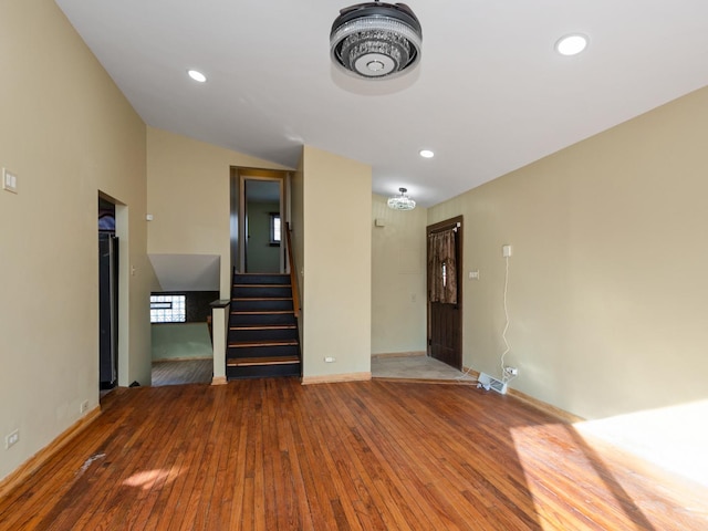 unfurnished living room featuring stairway, recessed lighting, baseboards, and hardwood / wood-style floors